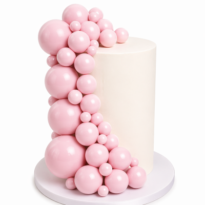 Bolo branco decorado com esferas rosas brilhantes em diferentes tamanhos.