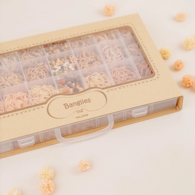 Caixa organizadora transparente com elásticos para cabelo em tons neutros e acessórios