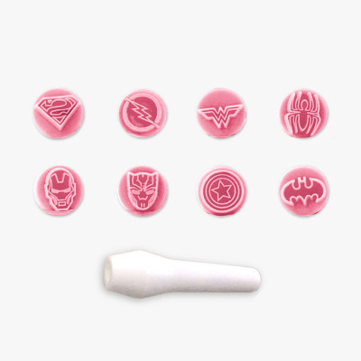 Botões rosa com símbolos de super-heróis e objeto branco cilíndrico.