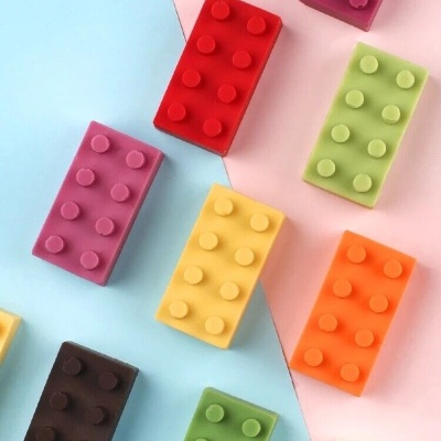 Blocos retangulares coloridos com botões em relevo sobre fundo azul e rosa.