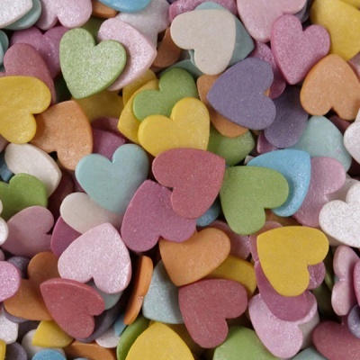 Confeitos em forma de coração coloridos, textura granulada, várias cores pastel