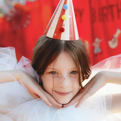 Menina com chapéu de festa vermelho e branco e vestido branco de tule