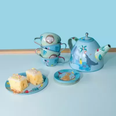 Conjunto de chá azul com decoração de animais e duas fatias de bolo