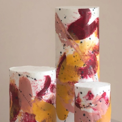 Velas cilíndricas decorativas com padrões abstratos coloridos em branco, vermelho, amarelo e rosa