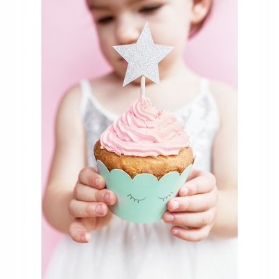 Criança segurando cupcake com cobertura rosa e estrela prateada