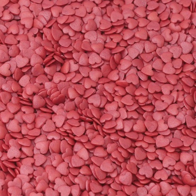 Pequenos confeitos cor-de-rosa em forma de coração agrupados.