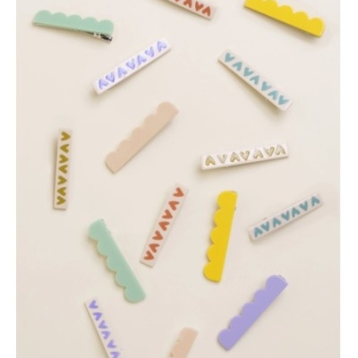 Clipe de cabelo colorido e decorado com triângulos sobre fundo branco