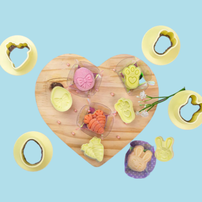 Moldes amarelos para biscoitos com biscoitos coloridos sobre base de madeira em forma de coração