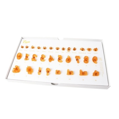 Conjunto de peças em massa laranja para moldar letras e símbolos numa caixa branca