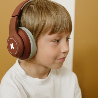 Criança a usar auscultadores castanhos com K branco iluminado