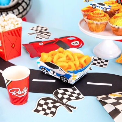 Mesa decorada para festa infantil com tema de corrida e elementos de papel e comida colorida