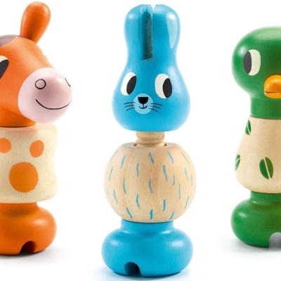 Três bonecos de madeira coloridos com formas de animais, girafa, coelho e pato.