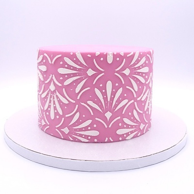 Bolo redondo rosa com padrão branco