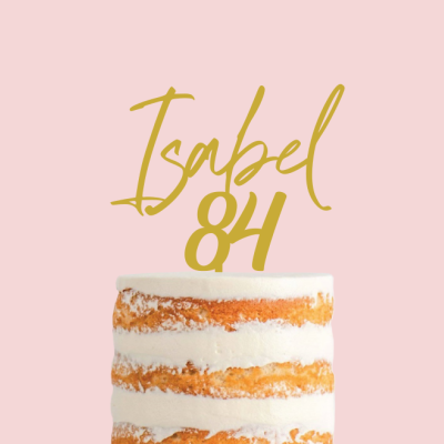 Bolo de camadas com cobertura branca e texto dourado Isabel 84 num fundo rosa