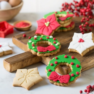 Biscoitos de Natal decorados em verde, vermelho e branco sobre tábuas de madeira