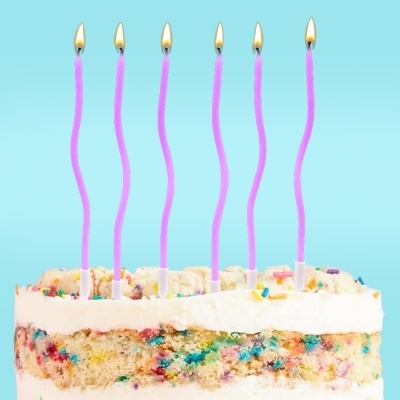 Bolo de aniversário com velas cor de rosa acesas