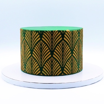 Bolo redondo com padrão dourado e preto e cobertura verde