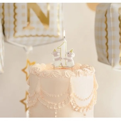 Bolo de aniversário branco com velas número 1 e balões brancos com detalhes dourados