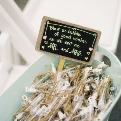 Recipientes para bolhas de sabão com cordas em bacia azul e cartaz de ardósia