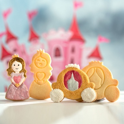 Biscoitos decorados em forma de princesa e carruagens com castelo ao fundo
