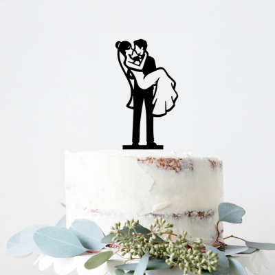 Topo de bolo com silhueta de casal a abraçar em bolo branco com folhas verdes na base