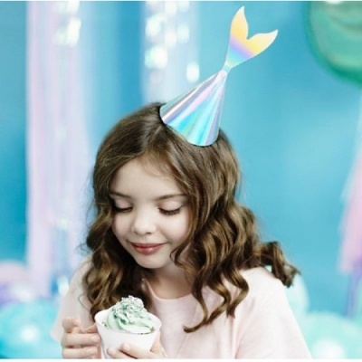 Menina com chapéu de festa holográfico segurando gelado em ambiente azul e rosa