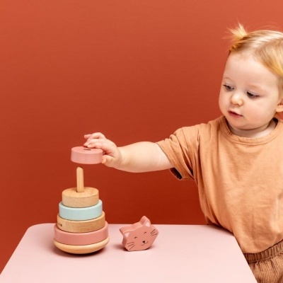 Criança a brincar com brinquedo de madeira empilhável em tons pastel