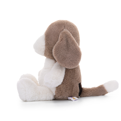 Pelúcia de cão castanho e branco sentada de lado num fundo branco