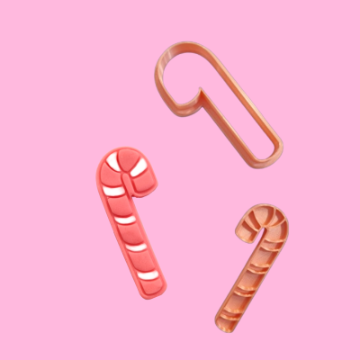 Três formas de pau de doce em plástico de várias cores sobre fundo rosa.