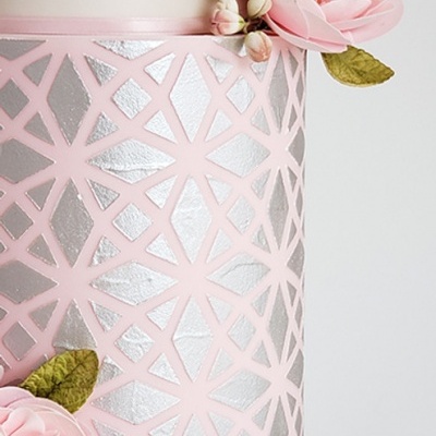 Recipiente decorativo rosa com padrão geométrico prateado e flores cor-de-rosa