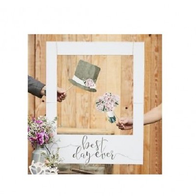quadro branco com frase best day ever, recortes de chapéu verde e ramo de flores, fundo de madeira