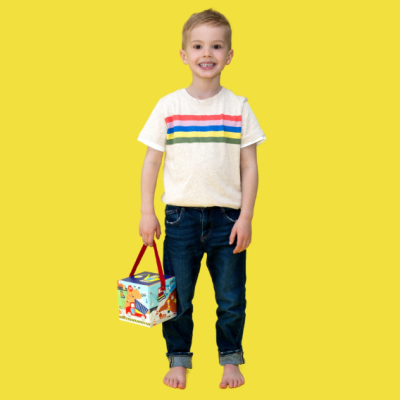 Criança com camiseta branca às riscas e calças de ganga segurando caixa colorida em fundo amarelo