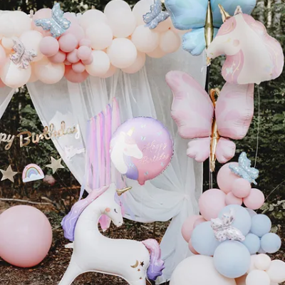 Decoração de festa com balões de unicórnio e borboletas em tons pastel