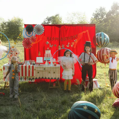 Crianças em festa de aniversário temática de circo ao ar livre com decoração colorida e balões grandes