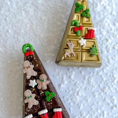 Dois chocolates triangulares decorados com motivos de Natal coloridos.