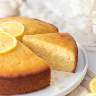 Bolo de limão redondo decorado com fatias de limão sobre prato branco