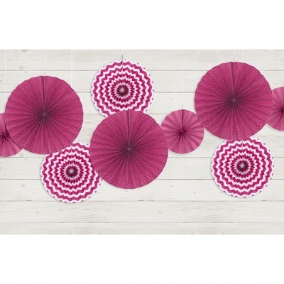 Decorações de papel rosa e branco em forma de leque sobre fundo de madeira clara