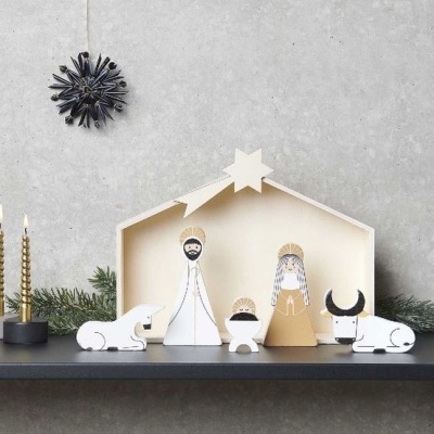 Presépio minimalista em madeira com figuras de Maria, José, menino Jesus, boi e burro, estábulo de madeira, vela dourada e enfeite preto pendurado.