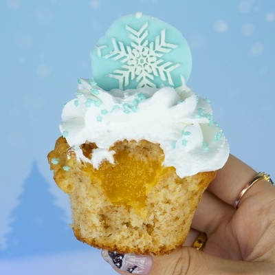 Muffin decorado com cobertura branca e disco azul com floco de neve