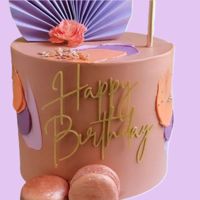 Bolo de aniversário rosa com decoração laranja e roxa, flor rosa e texto dourado