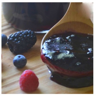 Compota de frutos vermelhos com amoras, mirtilos e framboesas numa tábua de madeira