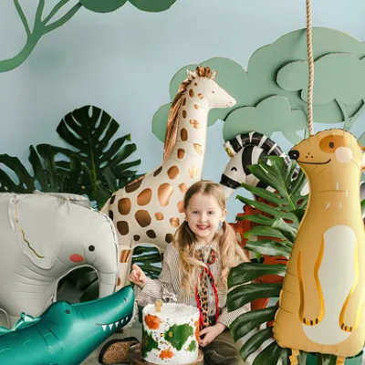 Criança com balões de animais selvagens e bolo em festa decorada