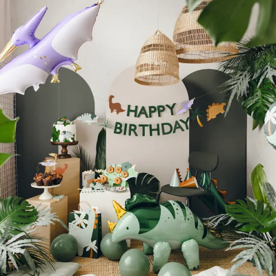 Decoração festa de aniversário com balões de dinossauros, bolo, cupcakes e letras HAPPY BIRTHDAY