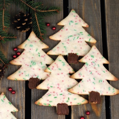 biscoitos em forma de árvore de Natal com glacê branco e granulados coloridos