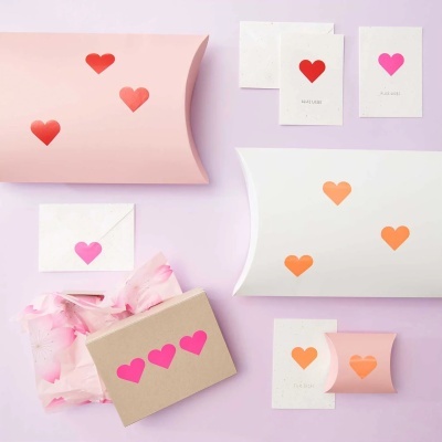 Conjunto de embalagens de presente com corações coloridos em fundo lilás