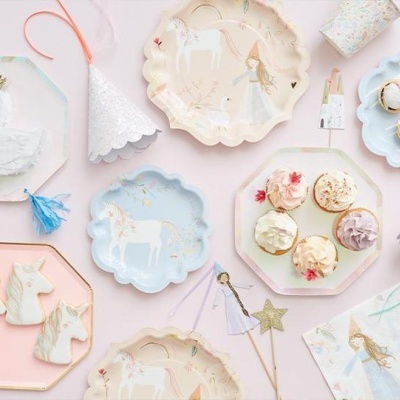 Artigos de festa infantil unicórnio em cores pastel sobre fundo rosa