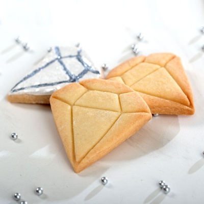 Bolachas em forma de diamante, duas com cor dourada e uma decorada com glacê branco e azul