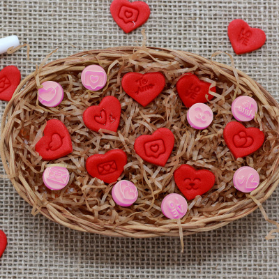 Cesta de vime com corações vermelhos e círculos rosa com padrões gravados