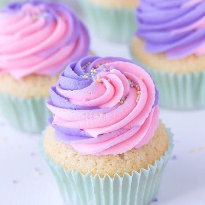 Cupcake com cobertura rosa e roxa em forma de espiral com pérolas