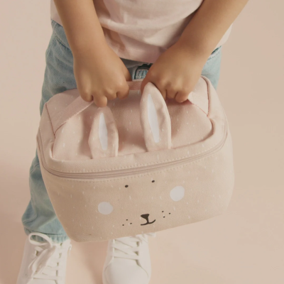 Mochila rosa claro com orelhas e rosto de coelho, criança segura com as mãos.